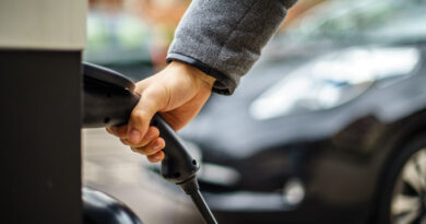 man plugging electric car into rapid charger uk